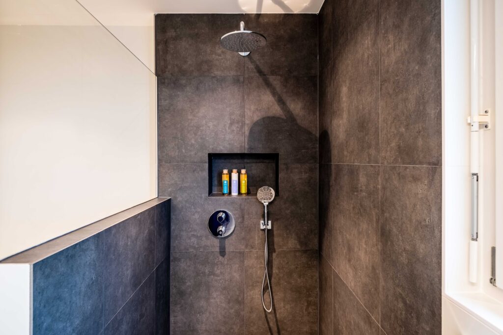 Modern tiled shower with fixture and niche for shower remodel planning
