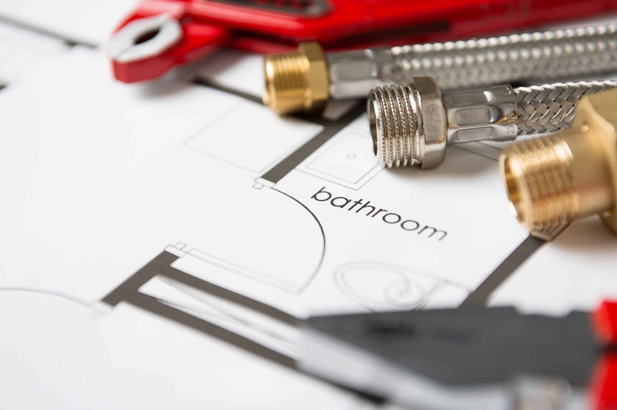 Bathroom blueprint with plumbing parts and wrench for estimate planning